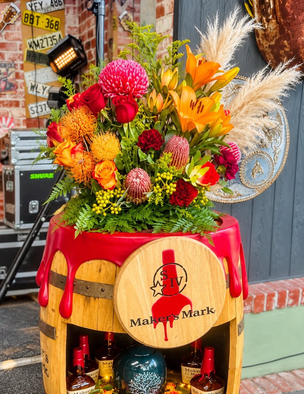 Danni's arrangement of waratah, pincushion protea, lilies, roses and pampas on a whisky barrel